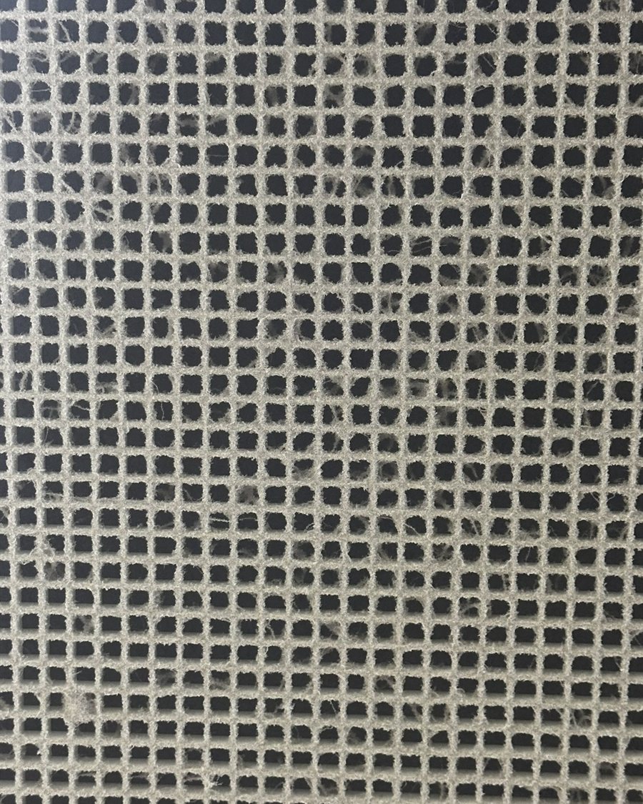 Return-air filter grille caked with dust and cobwebs before cleaning