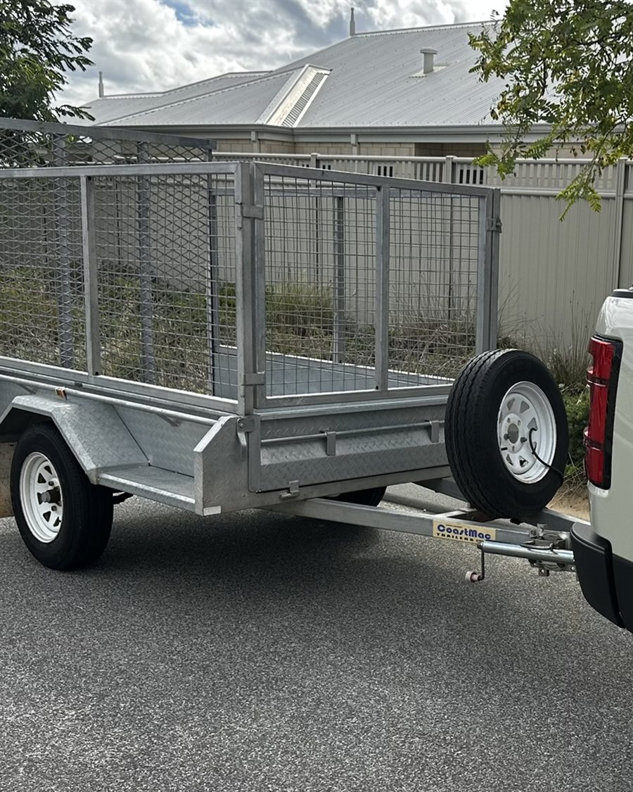 Caged trailer hitched to a ute for a rubbish removal and tip run